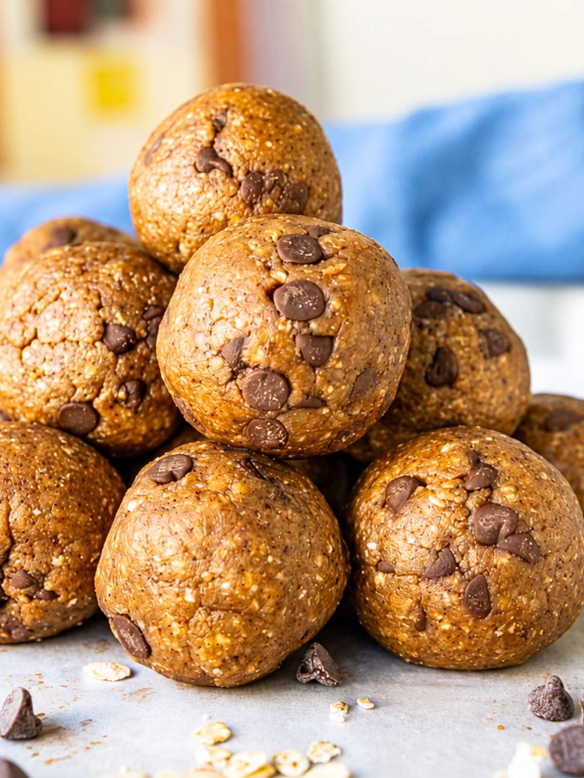 Stack of cookie dough energy balls with mini chocolate chips in natural daylight.