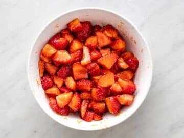 Step 1 Strawberries mixed with honey and lemon zest releasing bright juicy syrup.