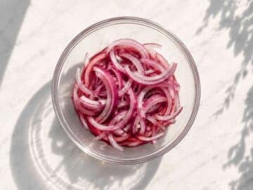 Step 1 thinly sliced red onion soaking in red wine vinegar in a small bowl.