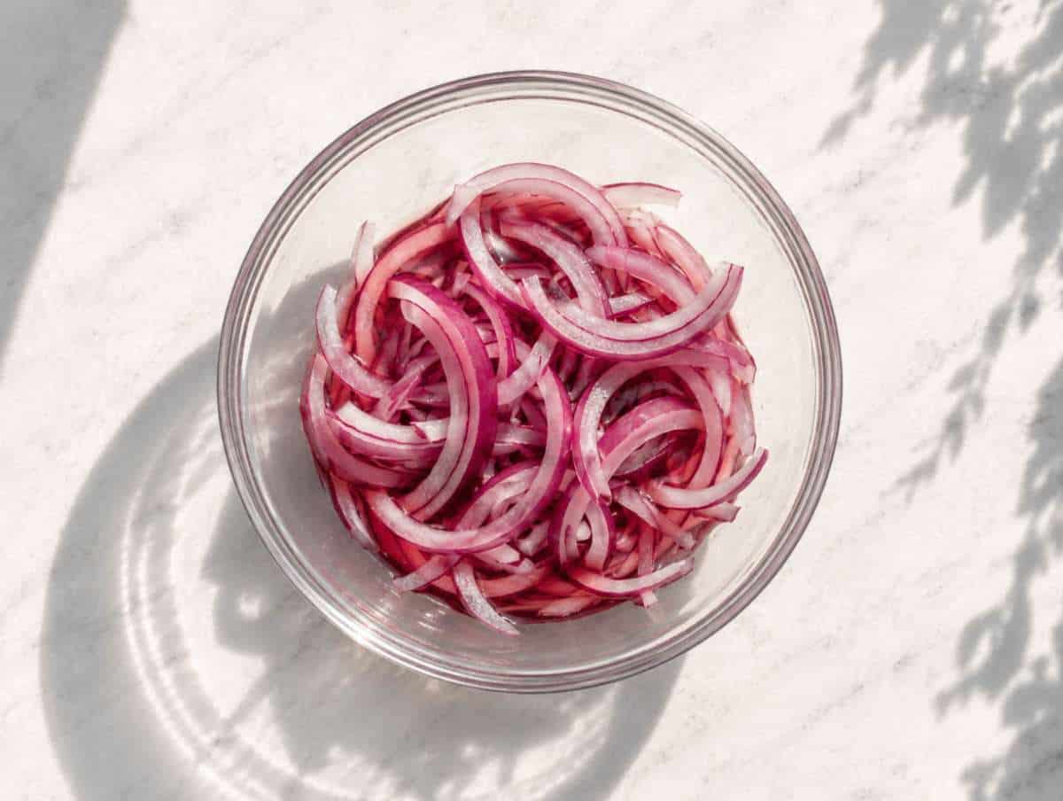 Step 1 thinly sliced red onion soaking in red wine vinegar in a small bowl.