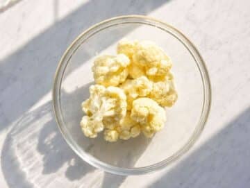 Step 2 Cauliflower florets in a glass bowl ready for quick microwave cooking.