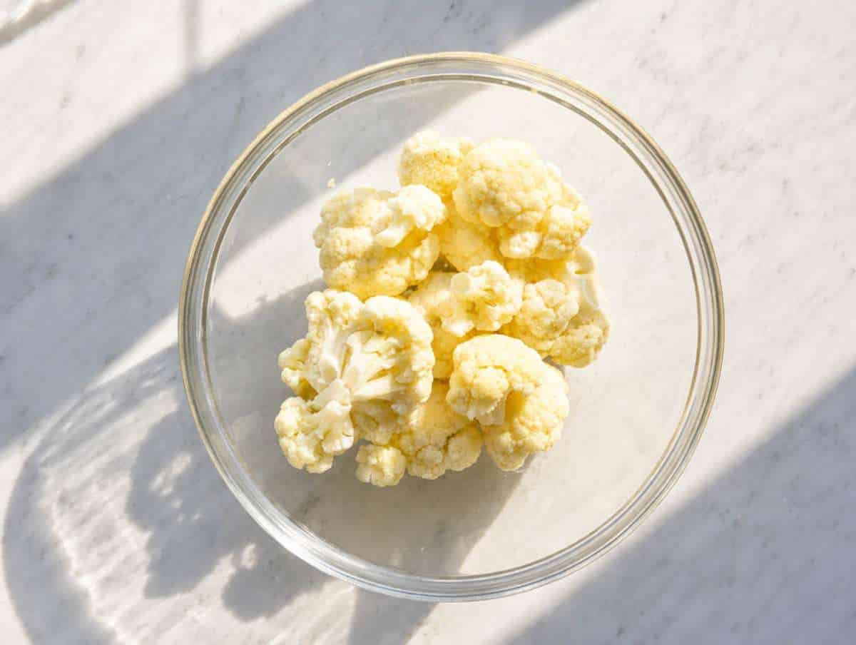 Step 2 Cauliflower florets in a glass bowl ready for quick microwave cooking.