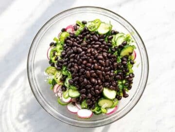 Step 2 Vegetables, beans, and herbs tossed evenly with lime dressing.