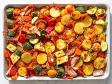 Step 2 Vegetables tossed with tomatoes, olive oil, garlic, and oregano before roasting.