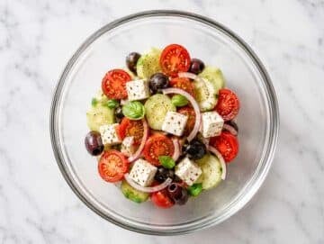 Step 3 Cucumber slices, cherry tomatoes, red onion, and Kalamata olives tossed with dressing