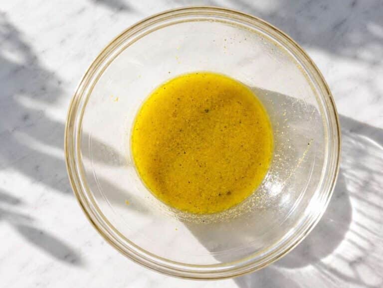 Step 3 Lemon Dijon dressing being whisked until smooth in a serving bowl.