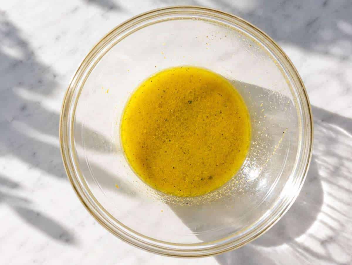 Step 3 Lemon Dijon dressing being whisked until smooth in a serving bowl.