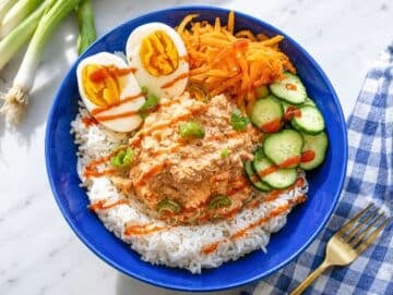 Step 3 Rice topped with chickpeas, eggs, cucumber, carrots, and onions.