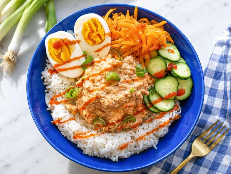 Step 3 Rice topped with chickpeas, eggs, cucumber, carrots, and onions.