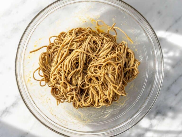 Step 3 Soba noodles tossed with creamy peanut dressing in bowl.