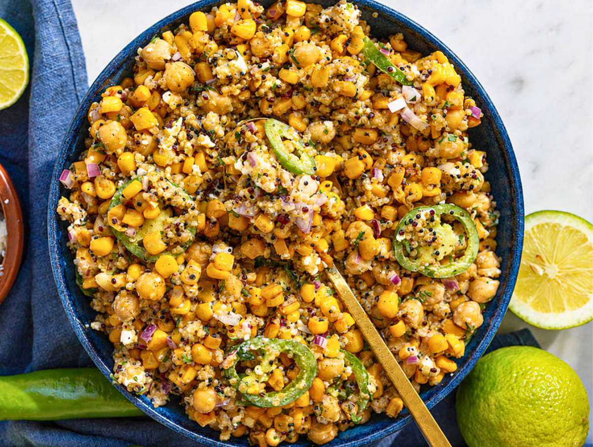 Step 4 Serving spoon lifting a portion of creamy corn salad.