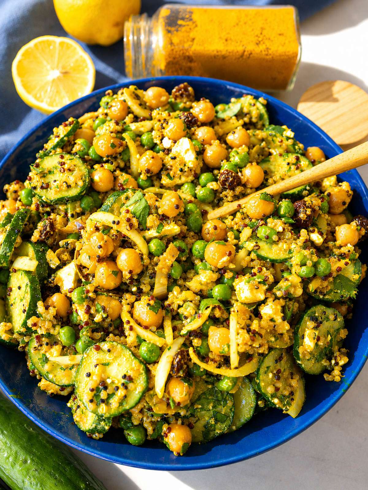 Turmeric chickpea salad with quinoa, feta, and fresh herbs in daylight.