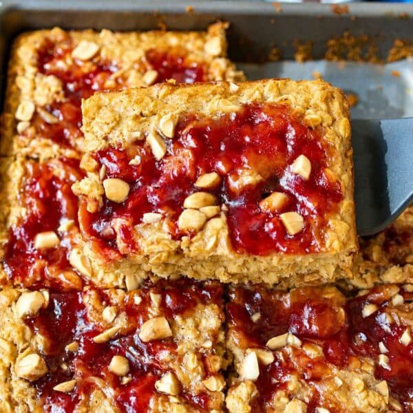 Baked oatmeal squares with strawberry jam swirls and peanuts.