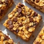 Banana oatmeal bars with Greek yogurt arranged on baking paper in daylight.