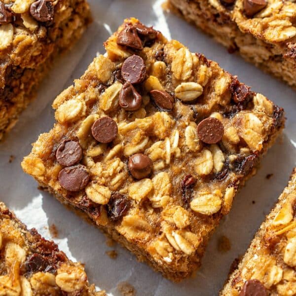 Banana oatmeal bars with Greek yogurt arranged on baking paper in daylight.