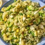 Bowl of lemon orzo salad with peas, feta, and fresh herbs.