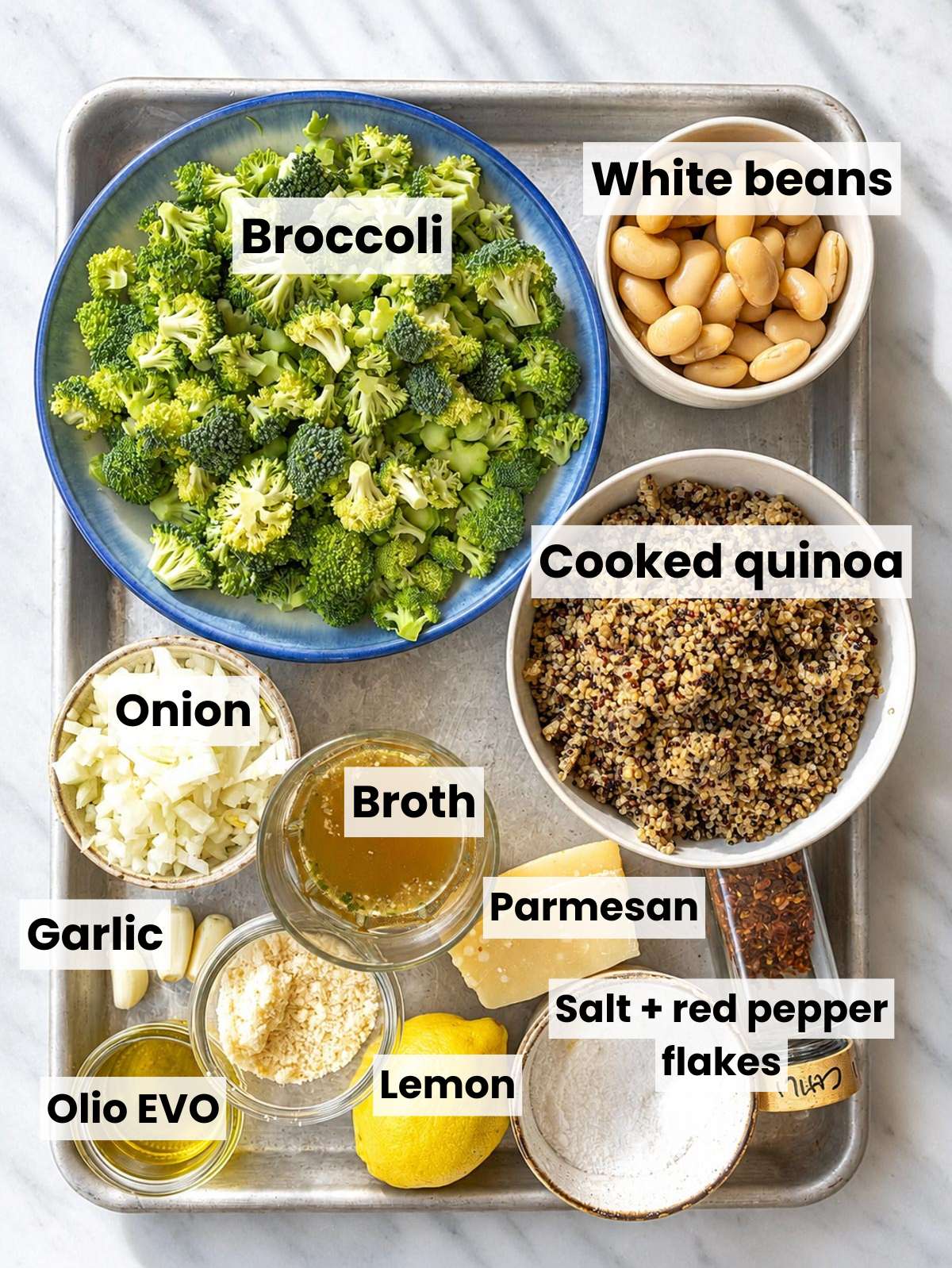 Broccoli quinoa skillet ingredients arranged on white marble in bright natural window light.