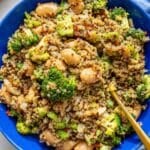 Broccoli quinoa skillet served in a blue bowl on white marble.