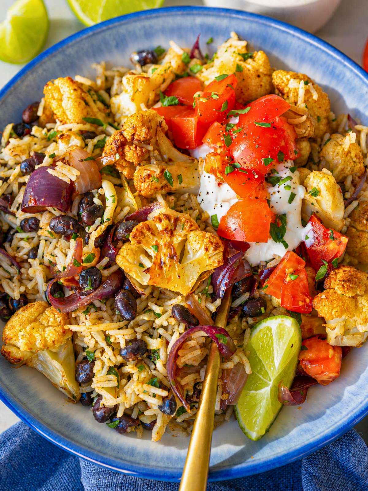 Cauliflower Burrito Bowl with roasted cauliflower, black beans, rice, cheese, and fresh herbs.