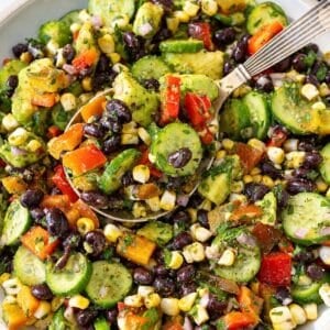 Chimichurri black bean salad served in white bowl on marble countertop.