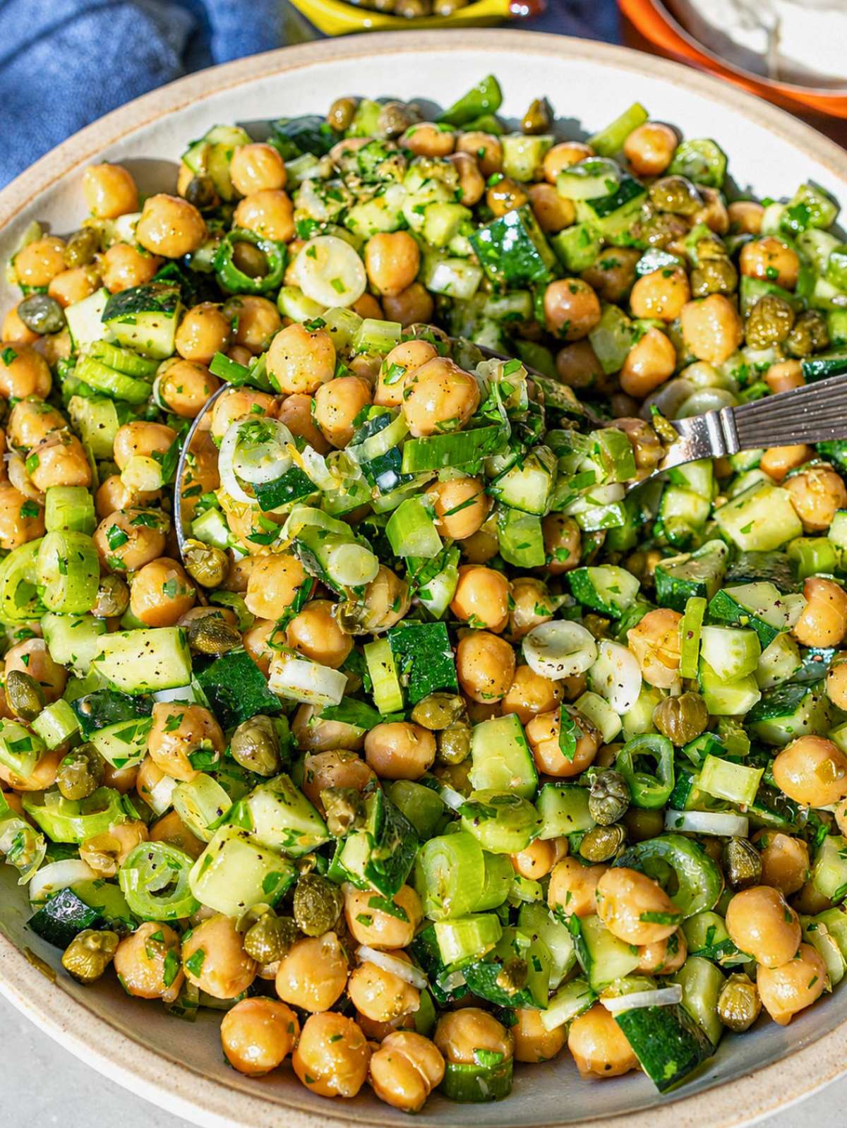 Close-up of glossy chickpeas with capers and fresh lemon dressing.