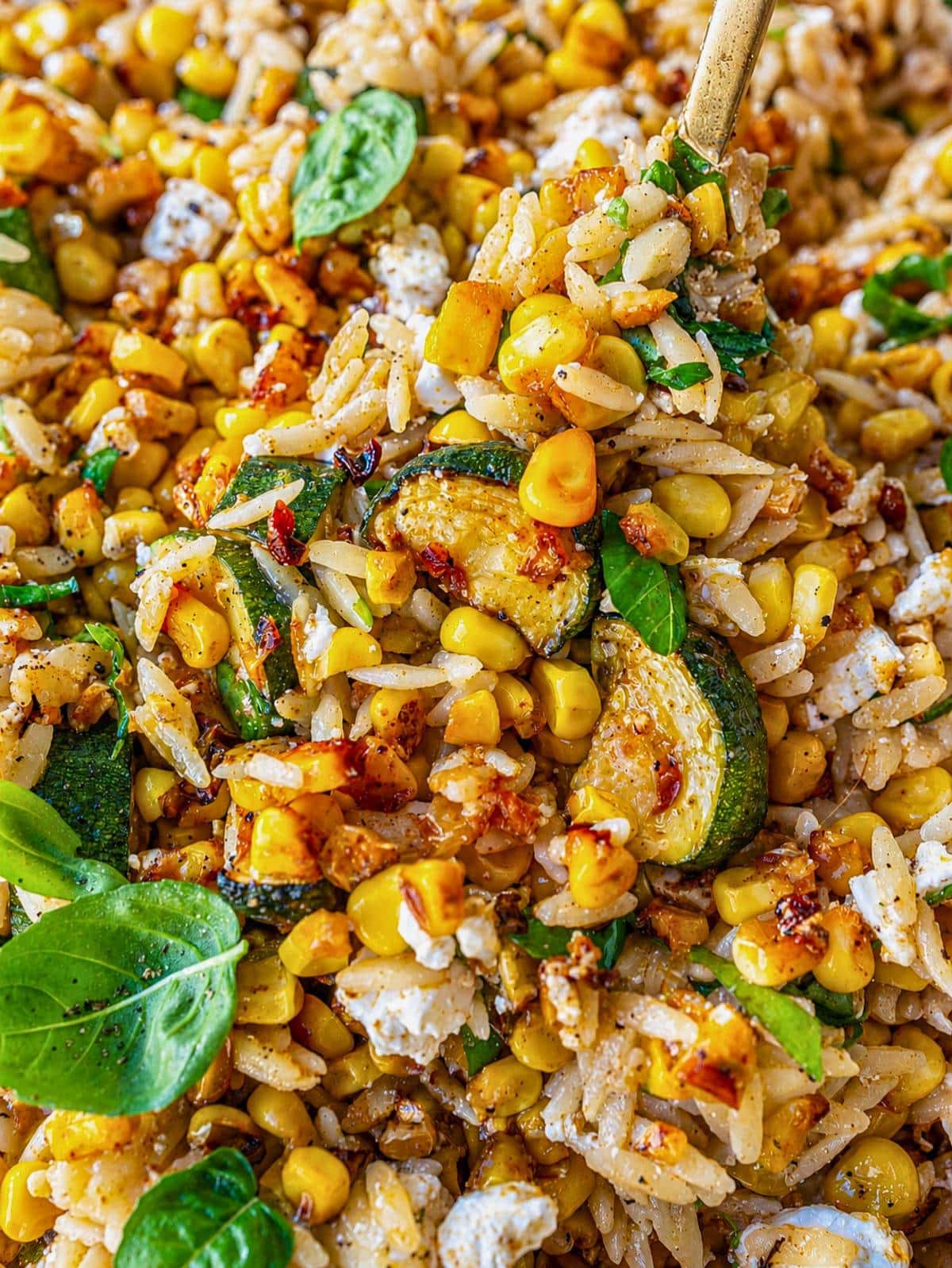 Close-up of roasted corn orzo with glossy orzo, feta, and charred corn.