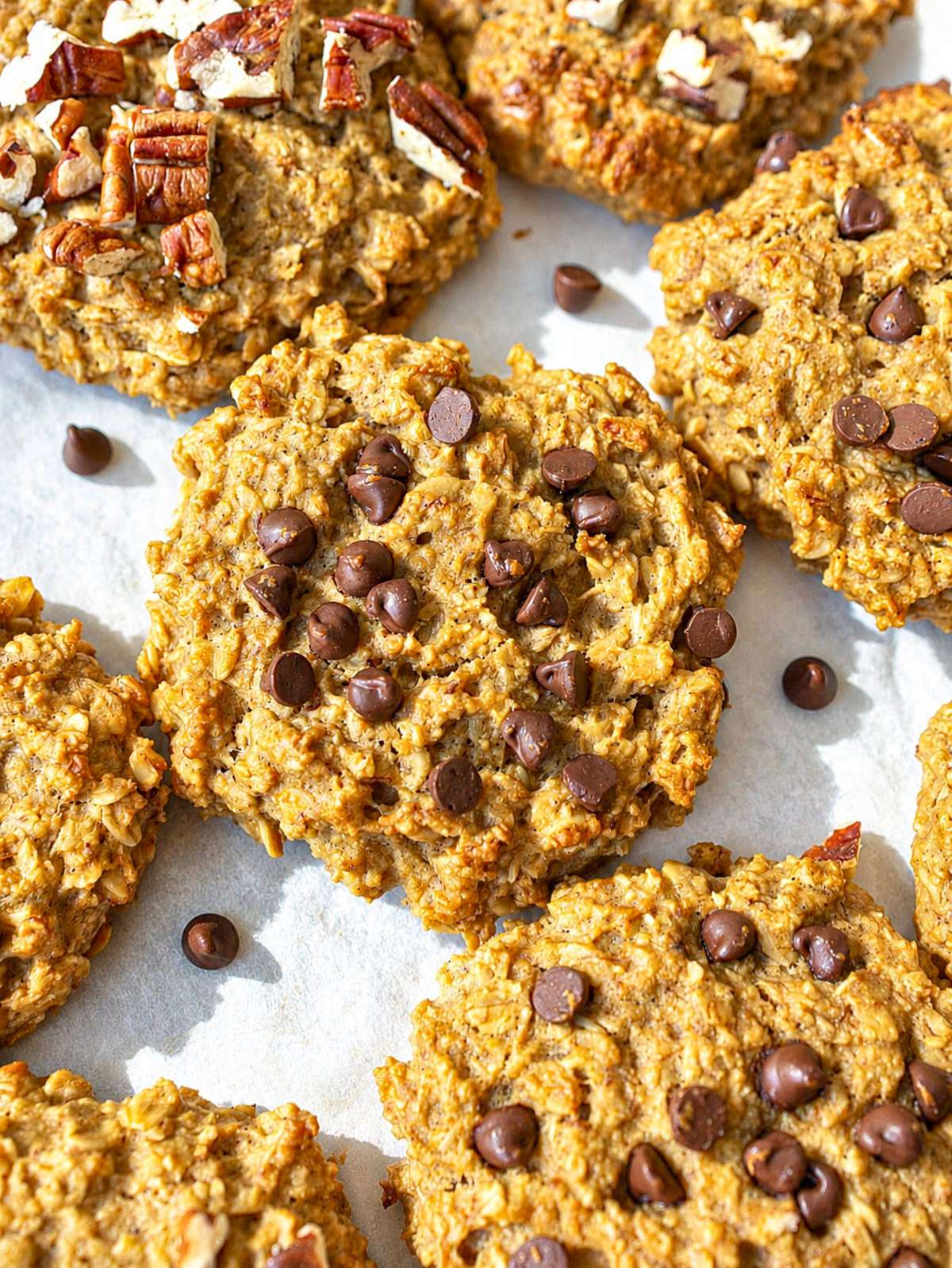 Close-up of soft banana peanut butter cookies with melted chocolate chips and chopped pecans.