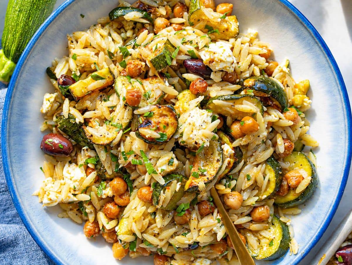 Fork with roasted zucchini orzo with glossy zucchini, feta, chickpeas, and olives