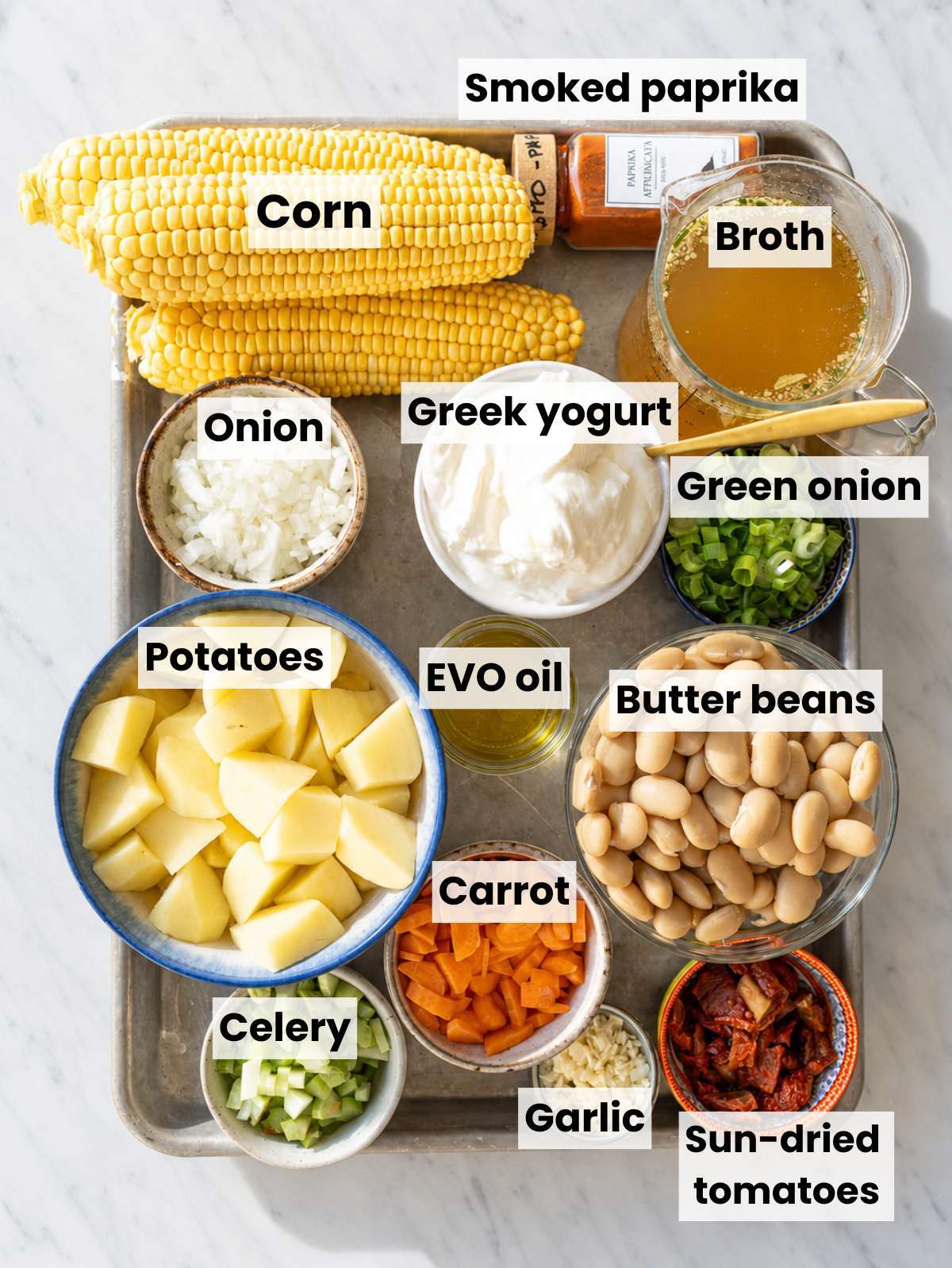 Ingredients for healthy corn chowder on a marble kitchen top.