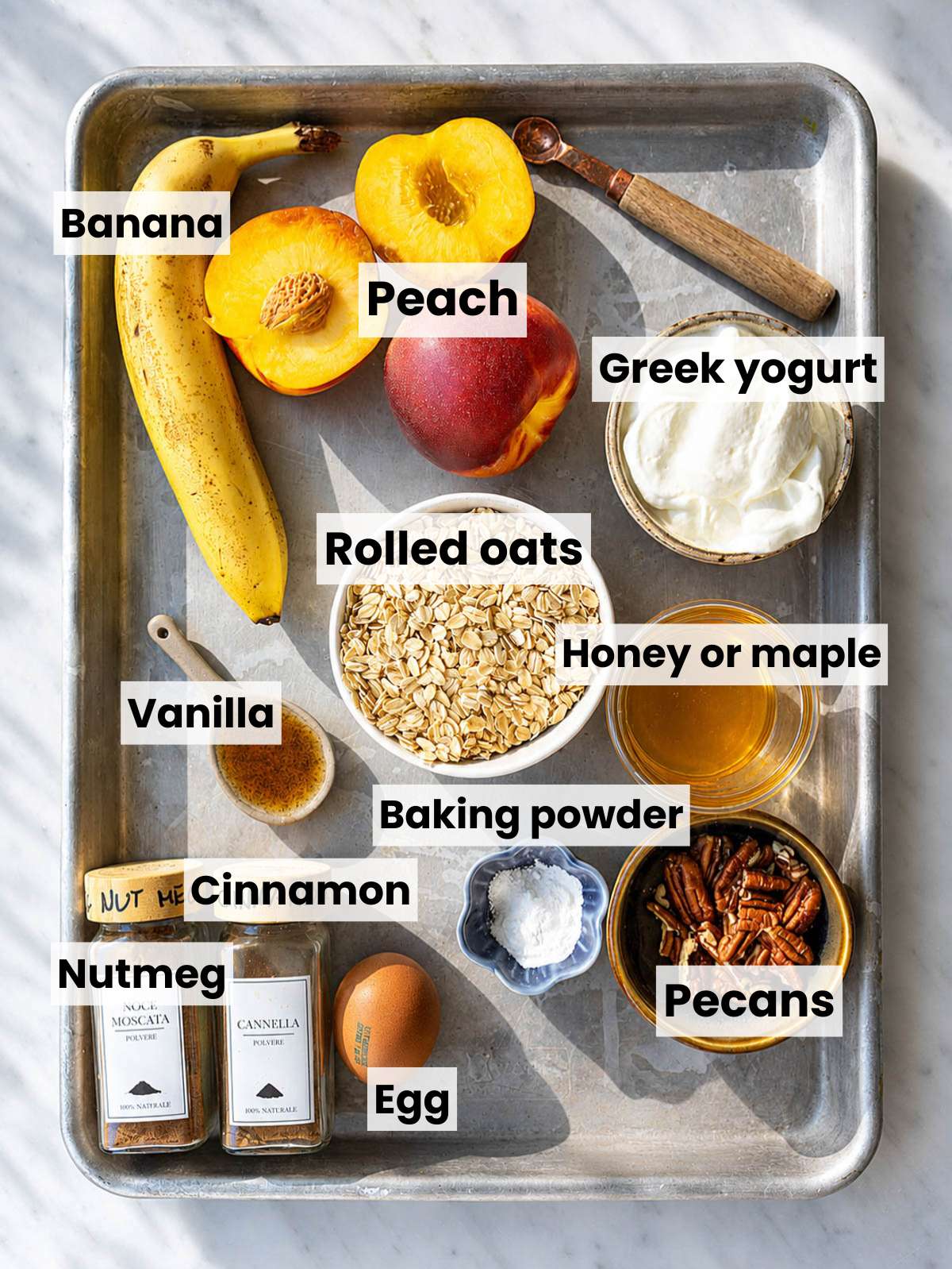 Ingredients for peach cobbler baked oatmeal cups on white marble in natural daylight.