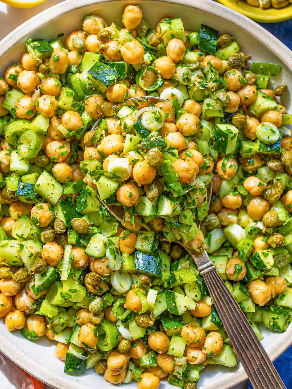 Piccata Chickpea Salad with glossy chickpeas, cucumber, celery, and parsley.