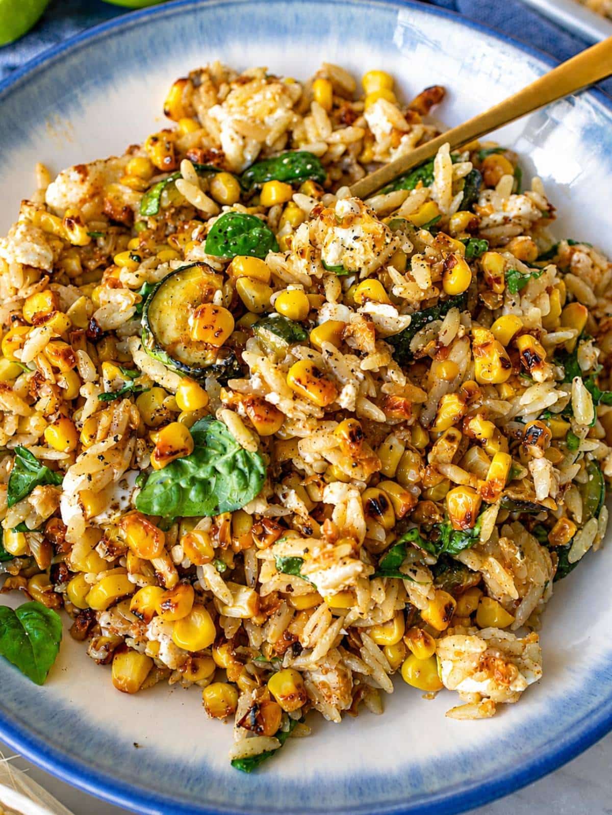 Roasted corn orzo with charred corn, zucchini, feta, and basil in a bowl.