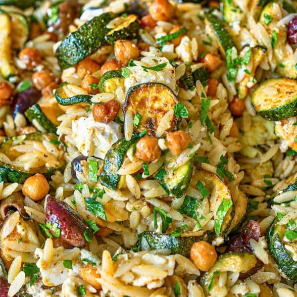 Sheet pan dinner of roasted zucchini orzo beside a bright window.