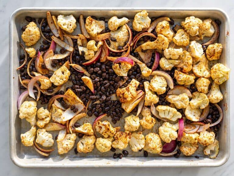 Step 1 Cauliflower, black beans, onions, oil, and spices tossed together on sheet pan.
