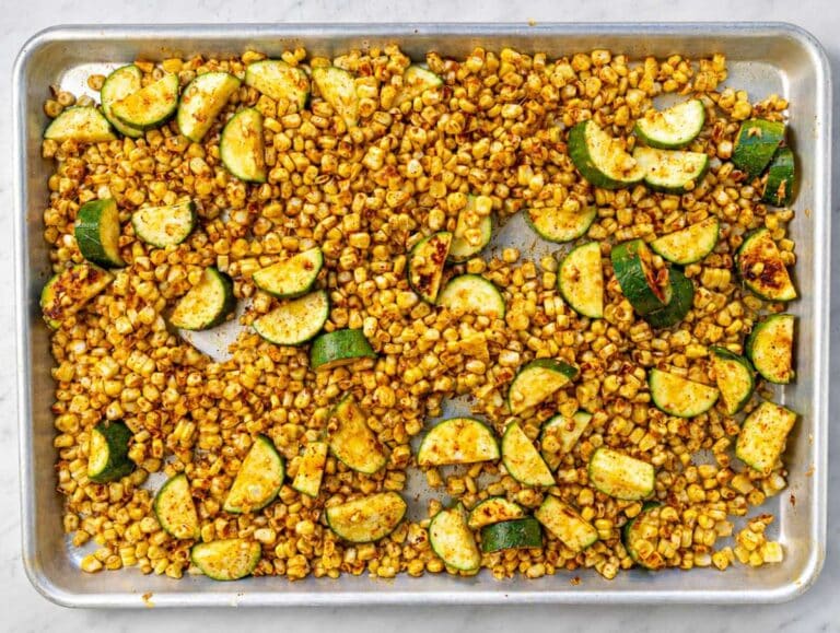 Step 1 Corn and zucchini seasoned on a sheet pan before roasting until lightly charred.