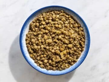 Step 1 French green lentils cooked until tender in a blue bowl.