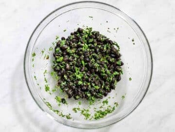 Step 1 Fresh chimichurri dressing mixed with black beans in a large glass mixing bowl.