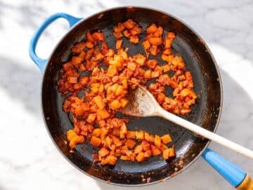 Step 1 Onion and bell pepper softening with garlic and tomato paste in skillet.