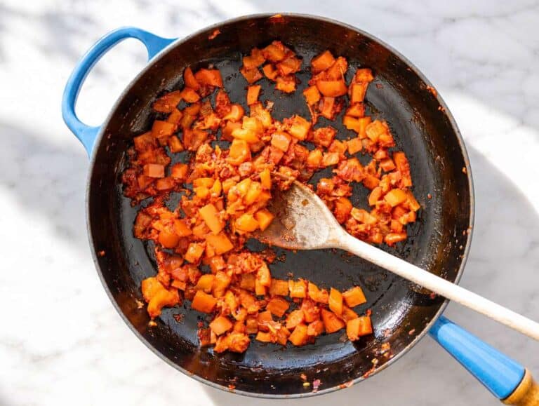 Step 1 Onion and bell pepper softening with garlic and tomato paste in skillet.