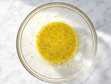 Step 1 Whisking lemon piccata dressing with olive oil, capers, Dijon, and garlic.