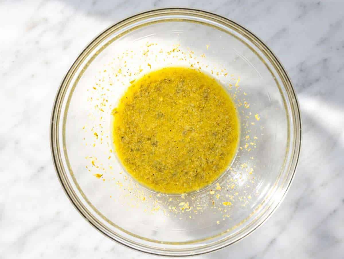 Step 1 Whisking lemon piccata dressing with olive oil, capers, Dijon, and garlic.