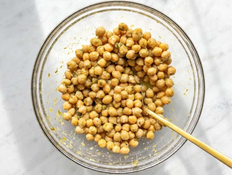 Step 2 Chickpeas marinating in glossy lemon piccata dressing inside a large bowl.