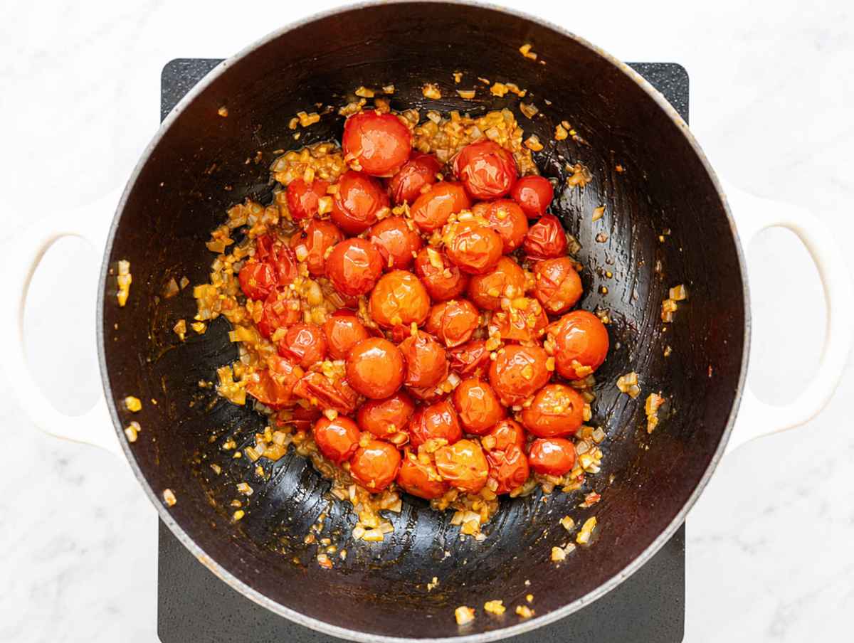 Step 2 Onion, garlic, oregano, and pepper flakes cooking with burst tomatoes.