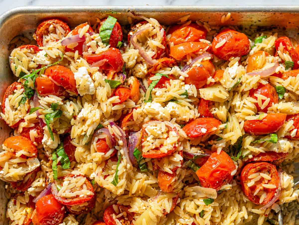 Step 3 Roasted vegetables, garlic, feta, basil, and orzo tossed together on sheet pan.
