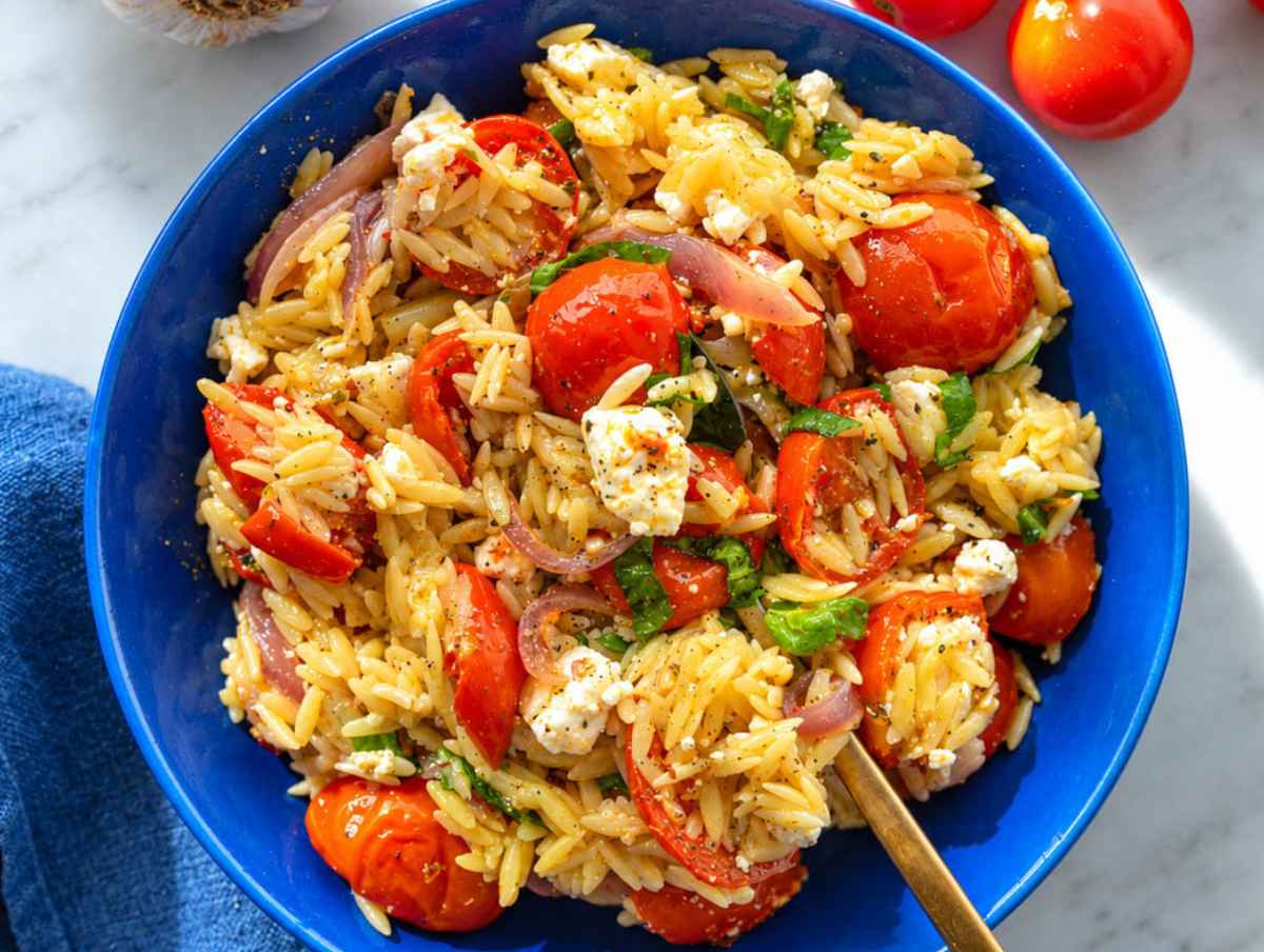 Step 4 Roasted tomato orzo garnished with basil, feta, black pepper, and olive oil.