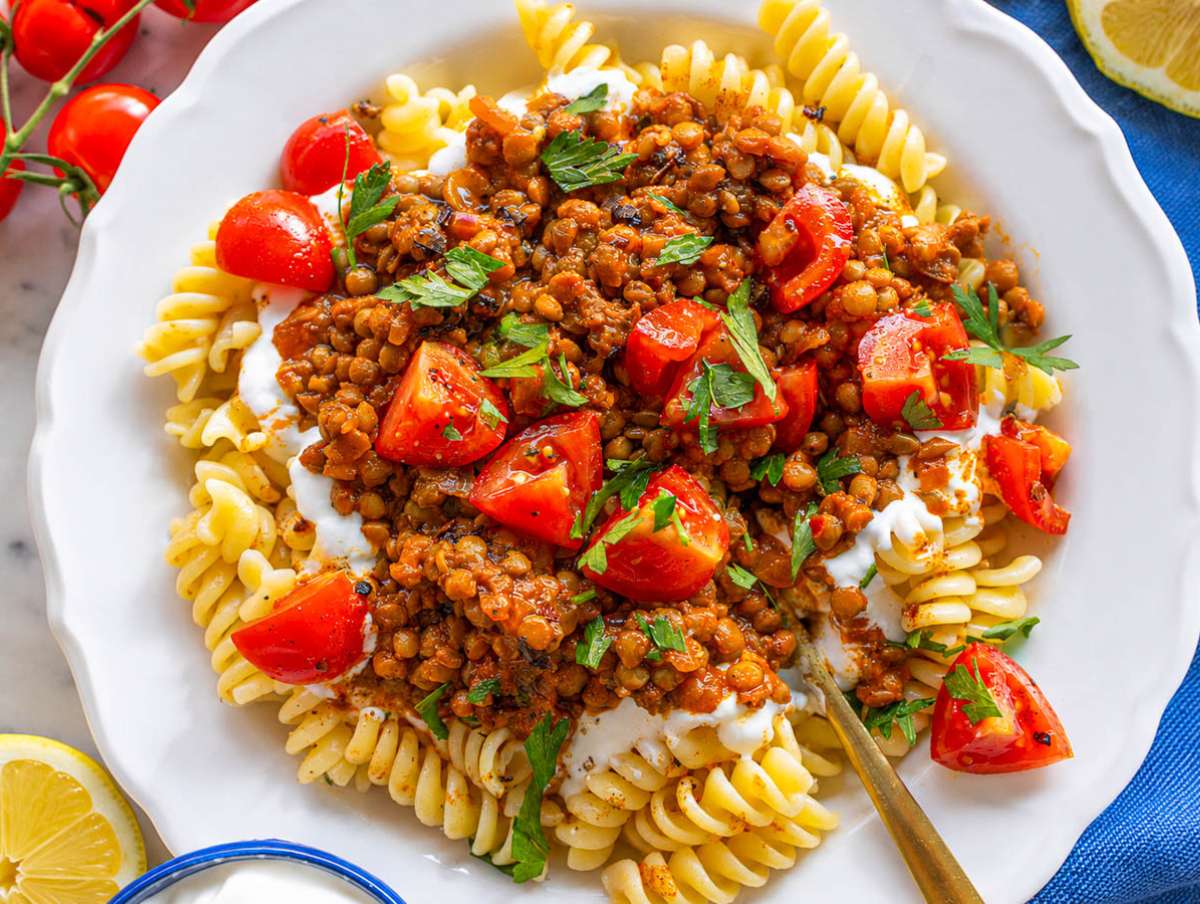 Step 5 Pasta layered with yogurt, lentil sauce, paprika oil, tomatoes, parsley, and lemon.