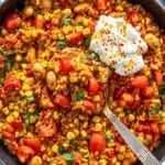 Summer succotash rice bowl garnished with parsley and Greek yogurt.