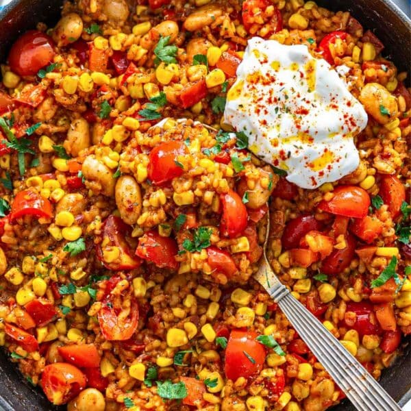 Summer succotash rice bowl garnished with parsley and Greek yogurt.