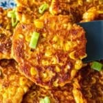 Sweet potato corn patty on a spatula with green onion.