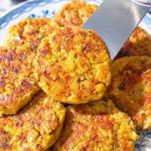 Chickpea potato patties with fresh lemon on a blue plate.